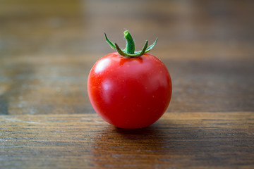 single tomato of pachino isolated on wooden background
