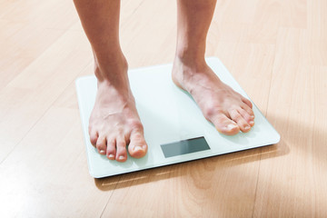 Legs on the scales. Checking the weight. Losing weight.