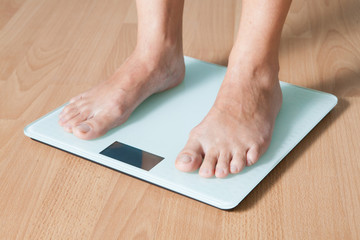 Legs on the scales. Checking the weight. Losing weight.