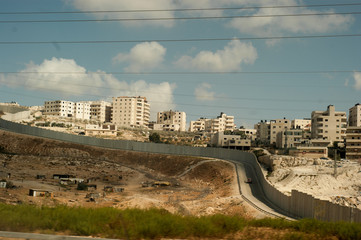 Small village and palestinian town on the hill behind separation wall on the West Bank in Israel.