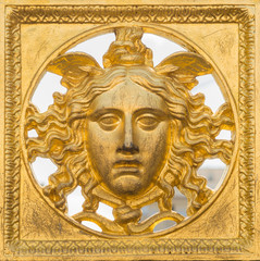 Ancient baroque golden mask on a fence at Palazzo Reale, Turin