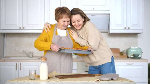 Grandmother And Granddaughter Baking Pastry In The Kitchen Together