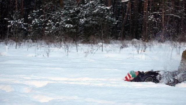 Man walks in the snow, slips and falls smoothly moving into slow motion