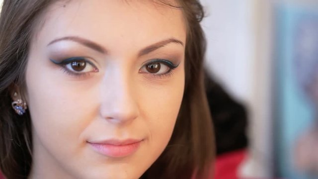 Makeup artist applies mascara.