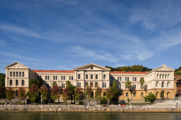 Fototapeta na wymiar The building of the University of Deusto next to the river in. Bilbao on a sunny day