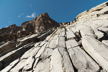 Wide angle view of a rocky slope on a sunny summer day. Structural hexagonal cliffs in the North...