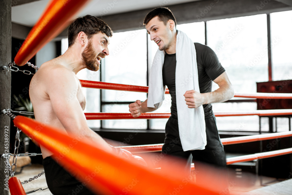 Canvas Prints Boxing trainer giving instructions during a break motivating a boxer sitting on the corner of the boxing ring