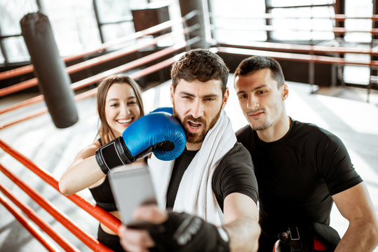 Friends making selfie portrait, having fun together during the sports break after the training on the boxing ring at the gym