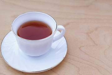 Cup of tea on light wooden background.