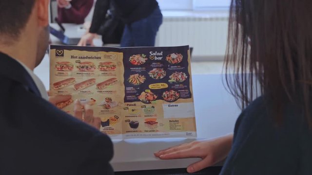 Girl choosing tortilla from the food flyer in the office