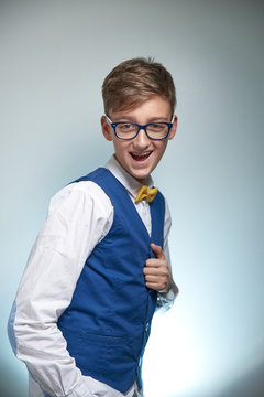 Boy teenager with braces in glasses. Wearing a shirt with a bow tie. On the teeth of dental braces.