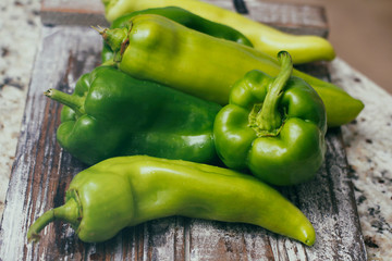 Set of green sweet peppers on wooden table. Fresh vegetables.