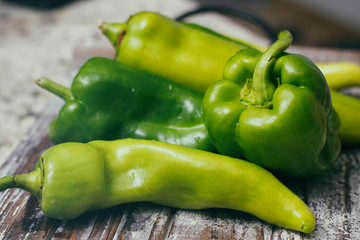 Set of green sweet peppers on wooden table. Fresh vegetables.