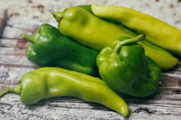 Set of green sweet peppers on wooden table. Fresh vegetables.