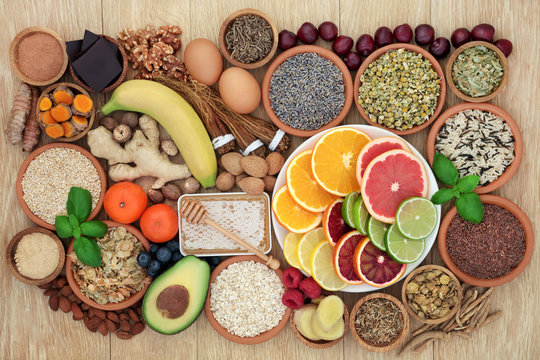 Super food to relieve anxiety and stress with herbs and spices used in herbal medicine that also help with relaxation and reduce chronic fatigue and depression. Top view on oak wood table.