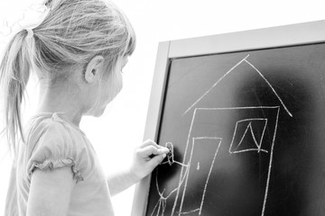 Happy baby girl beautiful painting on the easel on a white background