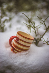 Colorful cup of tea in the snow. Hiking in the winter mountain