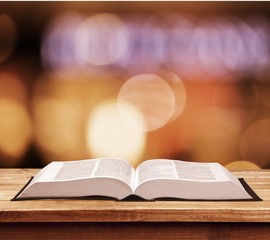 Open book on old wooden table.