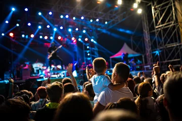 Fototapeten Concert seen from the crowds with a young boy and his father watching the performance © Calin Stan