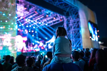 Foto auf Acrylglas Antireflex Young girl watching a concert from her dad shoulders © Calin Stan