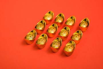 Chinese Gold Ingot for Chinese new year celebration shot with isolated red background