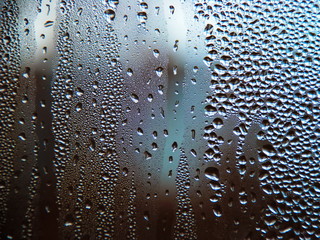 Drops of water on a cold glass.