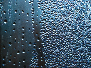 Drops of water on a cold glass.
