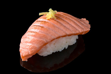 Delicious Sushi Nigiri with smoked Salmon (Sake) on black background. Traditional Japanese cuisine