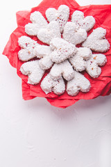 White heart shaped Valentine's day cookies with white glaze and coconut flakes on a red napkin. Copy space. Flat lay