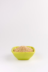 Quinoa in ceramic cup isolated on white background. Raw white quinoa