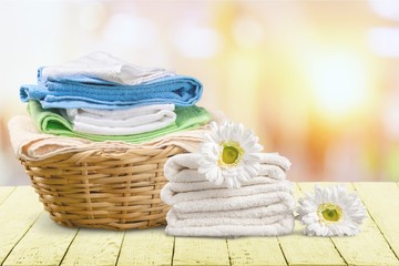Laundry Basket with colorful towels on background