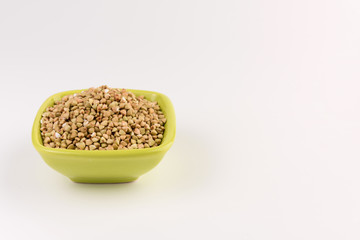 Natural fresh green buckwheat in bowl isolated on white background.