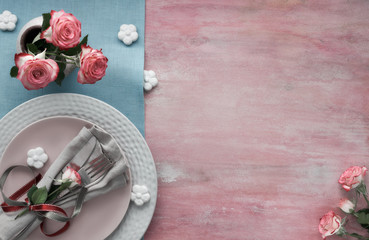 Valentine's day, birthday or anniversary table setup, top view on light pink background, copy-space