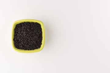 bowl of black wild rice isolated on white background, top view