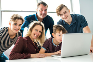 A big family looking in computer at home