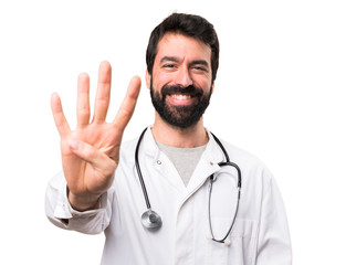 Young doctor counting four on white background