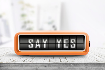 Say yes message sign on a wooden desk