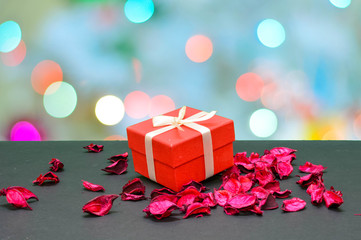 Lovely Gift box in between rose petals in bokeh light background