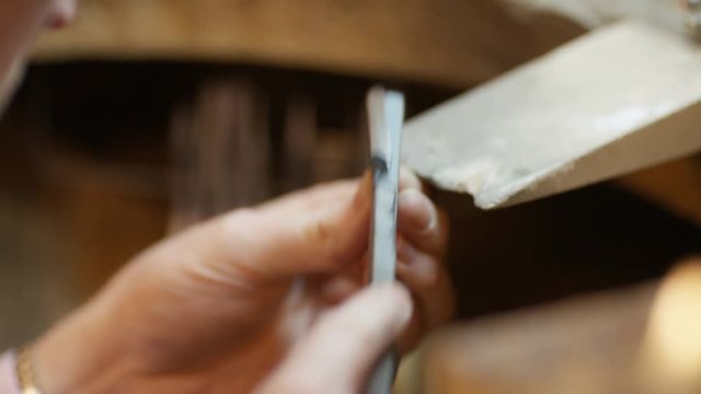 Close shot of jeweller polishing gem holder for a ring with an emery board 