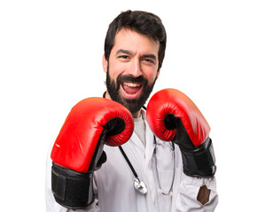 Young doctor with boxing gloves on white background