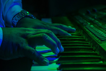 hand on green background playing piano