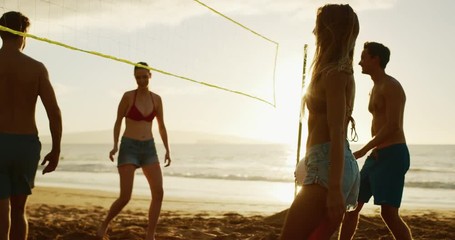 Active friends highfiving playing beach volleyball at sunset, cinematic summer lifestyle