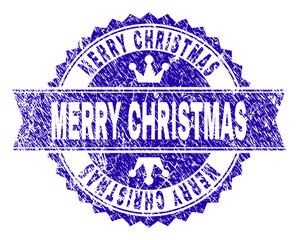 Obraz premium MERRY CHRISTMAS rosette stamp seal watermark with grunge texture. Designed with round rosette, ribbon and small crowns. Blue vector rubber watermark of MERRY CHRISTMAS title with retro texture.