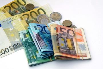 Euro bank notes and coins on white background