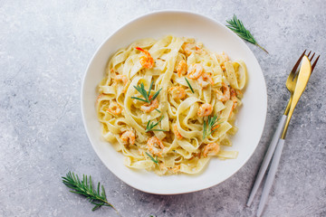 Italian pasta tagliatelle in a creamy sauce with shrimp
