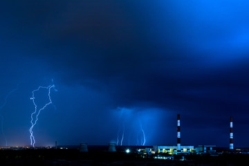 Naklejka na ściany i meble The cooling towers of thermal power station in the rainy night during the storm with the lightning