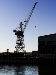 Fototapeta na wymiar Shipyard construction crane in low light