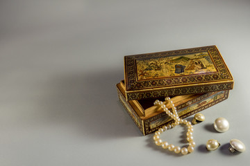 Old wooden jewel case with beautiful ornaments,  white pearl ear clips and necklace