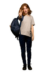 A full-length shot of a Young redhead student happy and counting three with fingers over isolated white background