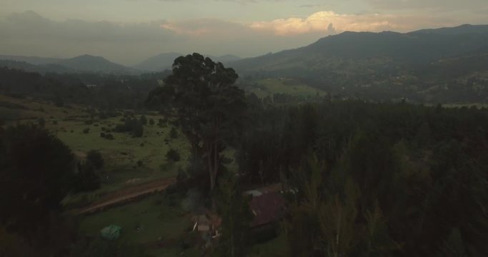 Sweeping aerial over forest trees to reveal green Colombian countryside near Bogota